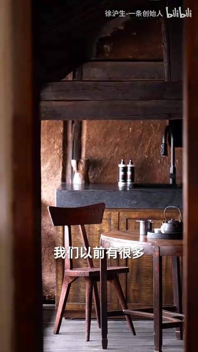 视频帧：下山口温泉院子，深色老木门框取景夯土茶室，老木椅与铁壶